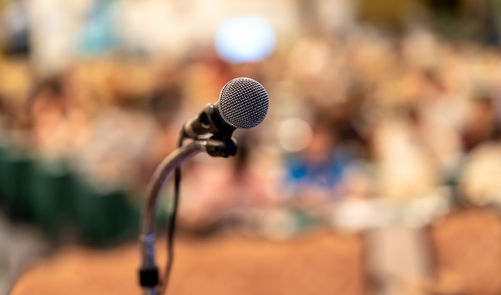 Microphone over the abstract blurred photo of conf 2024 02 23 05 04 09 utc